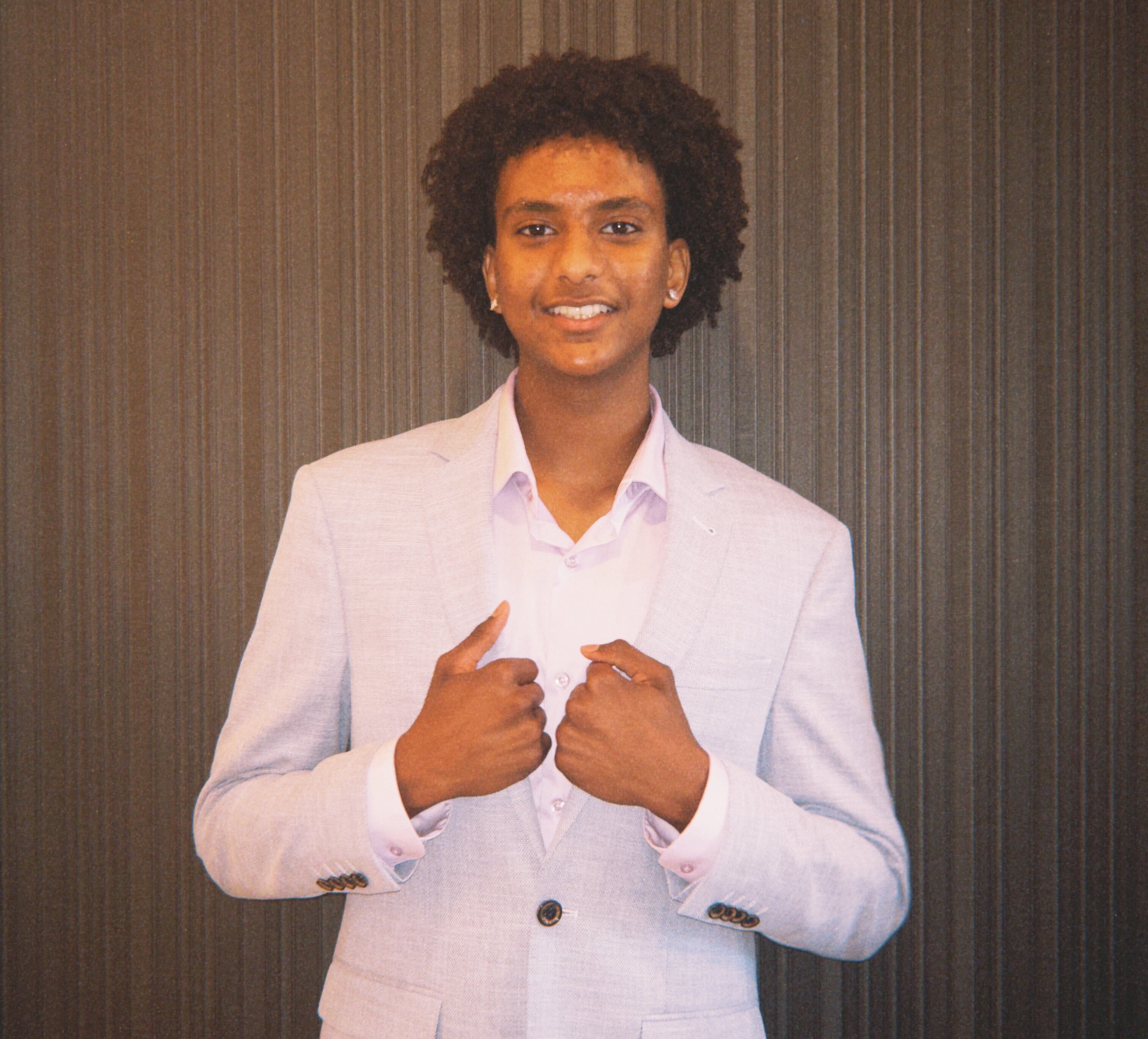 Mattania Biniam, 2025 East African Youth Scholarship recipient, in a white suit
